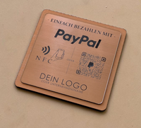 Quadratischer PayPal-Tischaufsteller aus dunklem Holz mit einer gravierten, roségold gebürsteten Kunststoffplatte. Auf der Platte sind ein QR-Code, ein NFC-Symbol und das PayPal-Logo zu sehen, perfekt geeignet für kontaktlose Zahlungen auf einer Ladentheke.