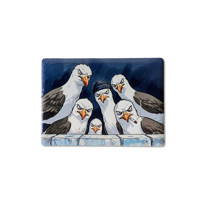 Rechteckiger Keramik-Kühlschrankmagnet (7x5 cm) im Querformat mit seidenmatter Glasur. Fünf grimmig dreinschauende Möwen, eine mit blauer Mütze und eine mit Zigarette, blicken über eine Mauer im spürbaren 3D-Relief.