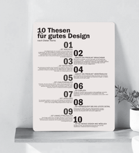 Ein hochkant ausgerichtetes, minimalistisches Metallschild im A3-Format mit den 10 Thesen für gutes Design nach Dieter Rams in deutscher Sprache. Die Typografie ist in klarem, schwarzen serifenlosen Text auf matt-weißem Hintergrund gedruckt. In den vier Ecken befinden sich dezente Vorbohrungen zur Montage.
