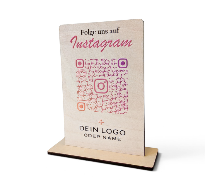 Hochkant stehender, personalisierter Tischaufsteller aus hellem Holz mit flachem Standfuß. Auf der Vorderseite sind ein Wunschtext („Folge uns auf Instagram“), ein QR-Code mit integriertem Instagram-Logo sowie ein Platzhalter für ein individuelles Firmenlogo präzise aufgedruckt.