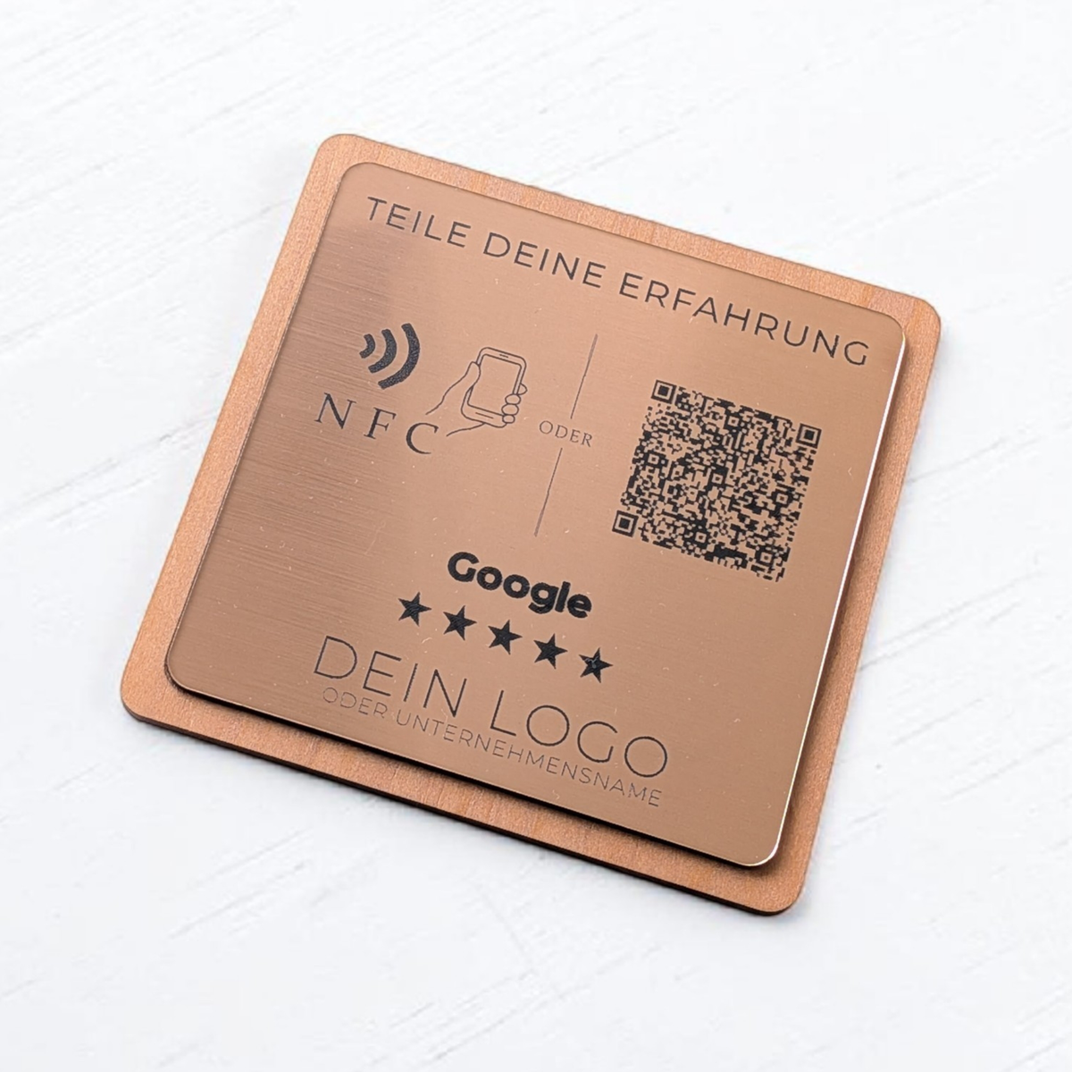 Ein quadratischer oder rechteckiger Tischaufsteller zur Kundenbewertung. Auf der Vorderseite befindet sich oben das farbige Google-Logo, gefolgt von der Aufforderung 'Bewerte uns auf Google'. Im Zentrum ist ein scannbarer QR-Code abgebildet. Unten rechts signalisiert ein Wellen-Symbol die integrierte NFC-Funktion zum kontaktlosen Scannen mit dem Smartphone.