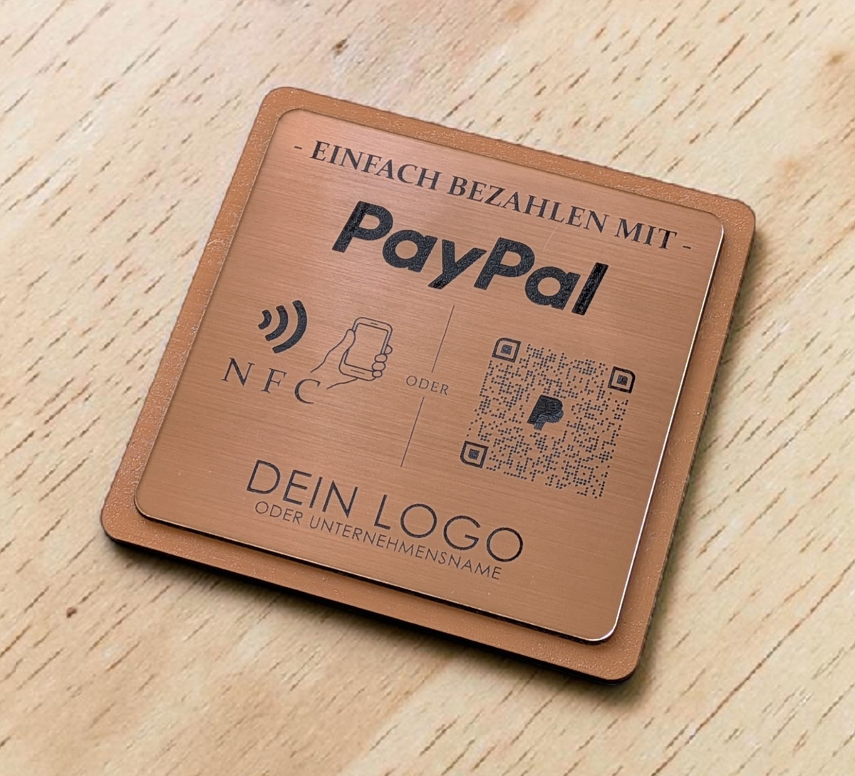 Quadratischer PayPal-Tischaufsteller aus dunklem Holz mit einer gravierten, roségold gebürsteten Kunststoffplatte. Auf der Platte sind ein QR-Code, ein NFC-Symbol und das PayPal-Logo zu sehen, perfekt geeignet für kontaktlose Zahlungen auf einer Ladentheke.