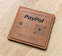 Quadratischer PayPal-Tischaufsteller aus dunklem Holz mit einer gravierten, roségold gebürsteten Kunststoffplatte. Auf der Platte sind ein QR-Code, ein NFC-Symbol und das PayPal-Logo zu sehen, perfekt geeignet für kontaktlose Zahlungen auf einer Ladentheke.