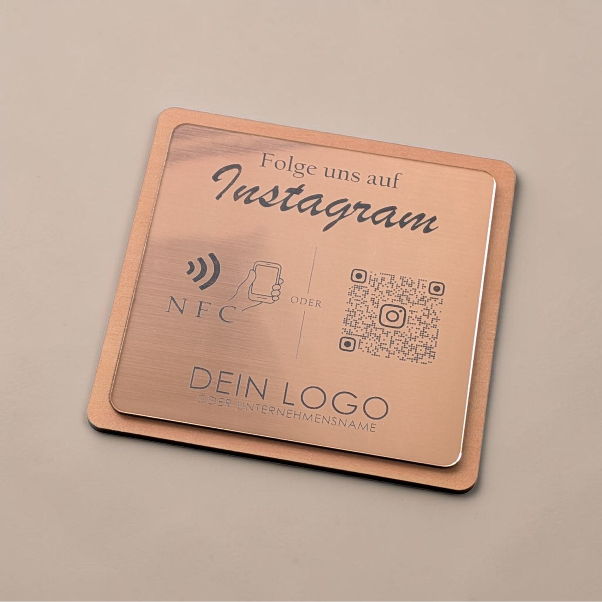 Quadratische, personalisierte Instagram-Follower-Platte aus graviertem Kunststoff in gebürsteter Roségold-Optik auf Holzträger. Hochpräzise Kontrast-Gravur von NFC-Icon und QR-Code.