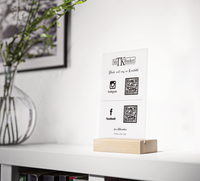 Dieses Acryl-Schild mit Holzfuß ist perfekt, um für dein Unternehmen zu werben. Du hast die Möglichkeit bis zu vier QR-Codes auf dem Schild, die auf deine Webseite oder Social Media Auftritte verweisen
