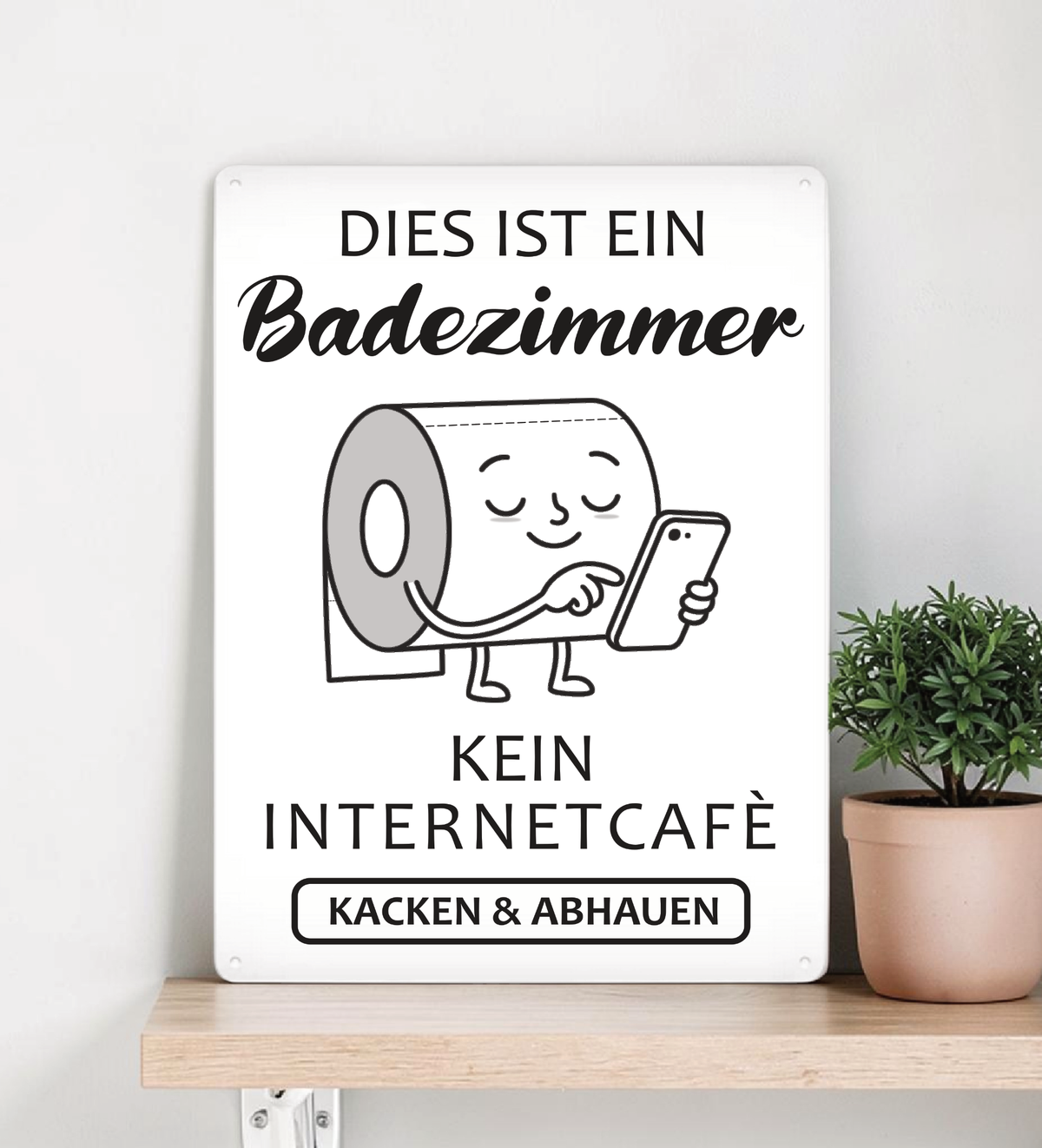 Ein rechteckiges, weißes Metallschild im Hochformat mit dem schwarzen Text „Das hier ist kein Internetcafé! Beeilt euch, macht euer Geschäft und geht wieder!“. Das Schild steht aufrecht vor einem schlichten, hellen Hintergrund.