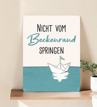 Rechteckiges Retro-Blechschild aus Metall mit dem Spruch „Nicht vom Beckenrand springen“, hochwertige Haptik, vier Eckbohrungen, vor weißem Hintergrund im Badezimmer-Stil.