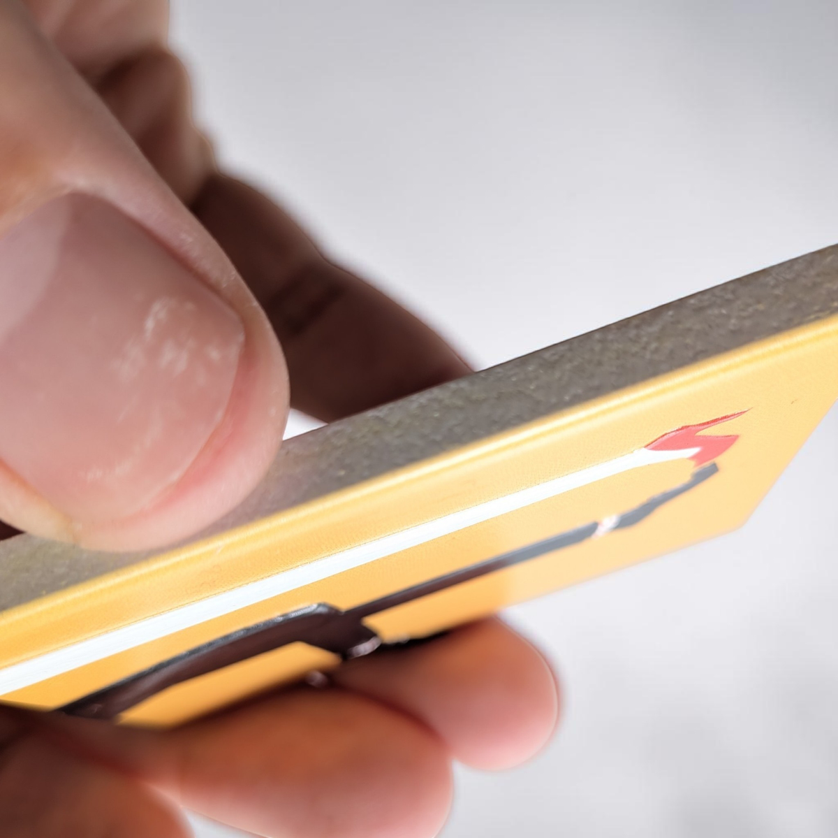 "Rechteckiger Keramik-Kühlschrankmagnet (7x5 cm) mit einem 3D-Relief. Zu sehen sind die Beine eines Paares: eine Person in roten High Heels und Herzchensocken, die andere in rot-weiß gestreiften Socken, auf hellem Hintergrund."
