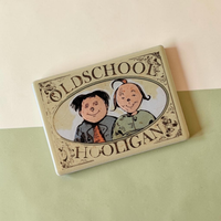 Rechteckiger Keramik-Kühlschrankmagnet (7x5 cm) im Vintage-Stil. Zu sehen ist ein ovales Medaillon mit den gezeichneten Gesichtern von Max und Moritz sowie dem Schriftzug 'OLDSCHOOL HOOLIGAN' im fühlbaren 3D-Relief.