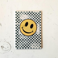 Rechteckiger weißer Keramikmagnet mit einem abstrahierten, gelben Smiley-Gesicht aus Quadraten. Die Oberfläche zeigt eine haptische Relief-Struktur und ein elegantes, seidenmattes Finish.