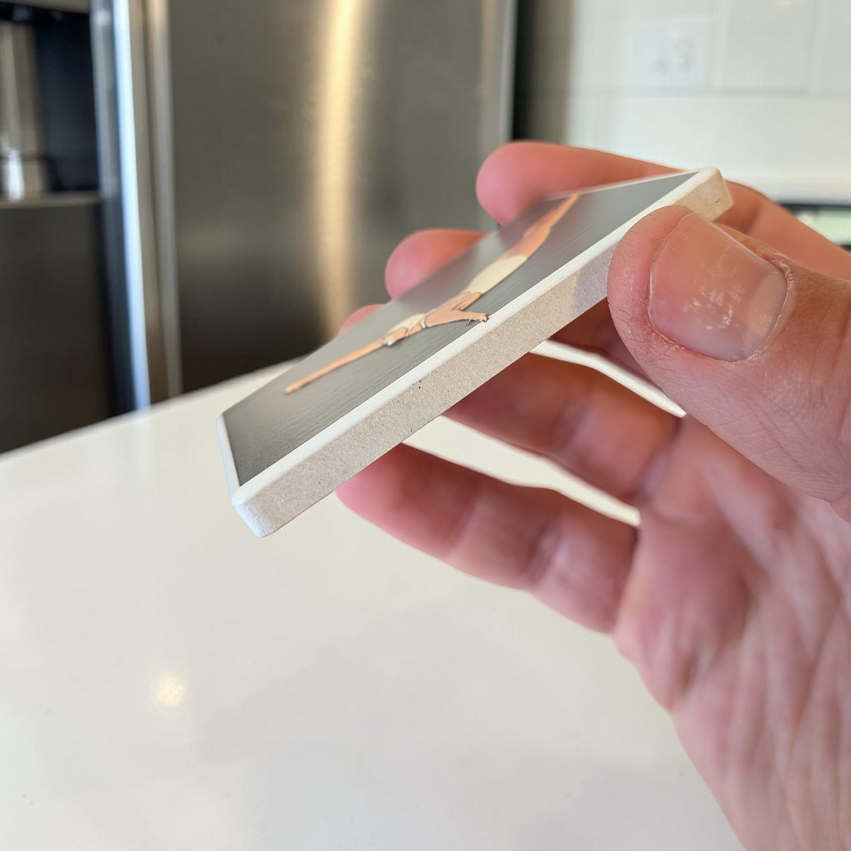 Rechteckiger weißer Keramikmagnet mit einer minimalistischen Illustration einer Turmspringerin im Sprung. Das Motiv hat ein fühlbares Relief und eine edle, seidenmatte Oberfläche.