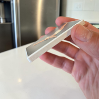 Rechteckiger weißer Keramikmagnet mit einer minimalistischen Illustration einer Turmspringerin im Sprung. Das Motiv hat ein fühlbares Relief und eine edle, seidenmatte Oberfläche.
