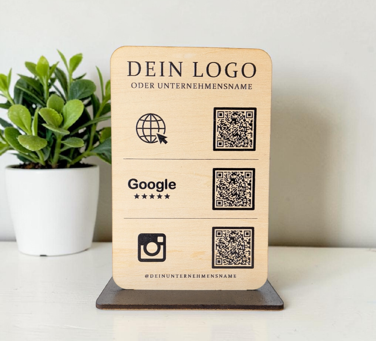 Personalisierter QR-Code Aufsteller aus hellem Holz mit schwarzem Standfuß, Logo-Gravur und drei QR-Codes für Website, Google-Bewertungen und Instagram.