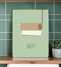 Das witzige Badezimmer-Bild aus Metall zeigt dir eine minimalistische Darstellung einer leeren Toilettenpapierrolle mit Halterung und dem Wort Shit.