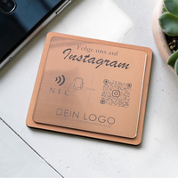 Quadratische, personalisierte Instagram-Follower-Platte aus graviertem Kunststoff in gebürsteter Roségold-Optik auf Holzträger. Hochpräzise Kontrast-Gravur von NFC-Icon und QR-Code.
