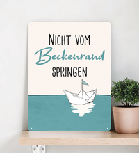 Rechteckiges Retro-Blechschild aus Metall mit dem Spruch „Nicht vom Beckenrand springen“, hochwertige Haptik, vier Eckbohrungen, vor weißem Hintergrund im Badezimmer-Stil.