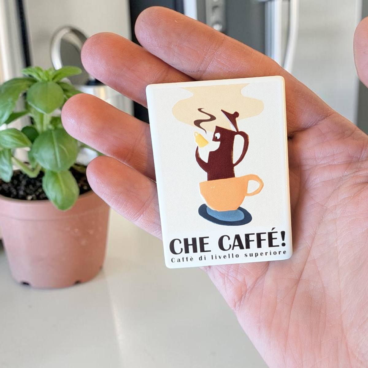 Rechteckiger Keramik-Kühlschrankmagnet mit italienischem Kaffee-Motiv „Che Caffé!“, Espressokanne in Tasse, Relief-Struktur, Vintage-Design in Beige- und Brauntönen.