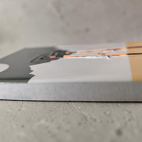 Rechteckiger Keramik-Kühlschrankmagnet (7x5 cm) mit zwei schwarzen Fahrrädern im Vordergrund vor weißen Bergen, einem graugrünen Himmel mit weißem Vollmond und einem ockergelben Boden mit spürbarem 3D-Relief.