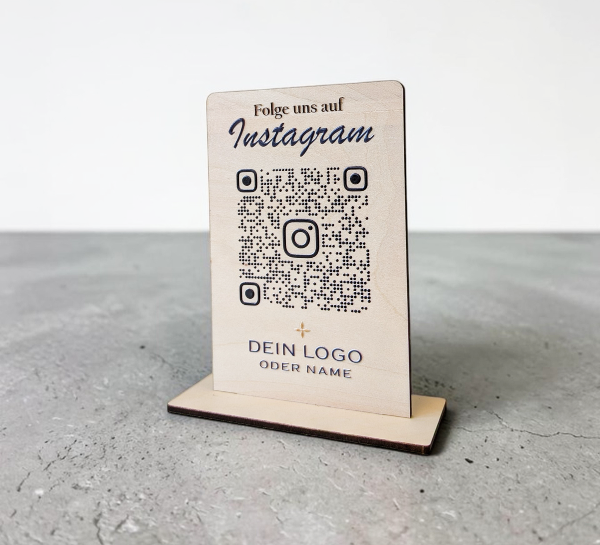Hochkant stehender, personalisierter Tischaufsteller aus hellem Holz mit flachem Standfuß. Auf der Vorderseite sind ein Wunschtext („Folge uns auf Instagram“), ein QR-Code mit integriertem Instagram-Logo sowie ein Platzhalter für ein individuelles Firmenlogo präzise aufgedruckt.