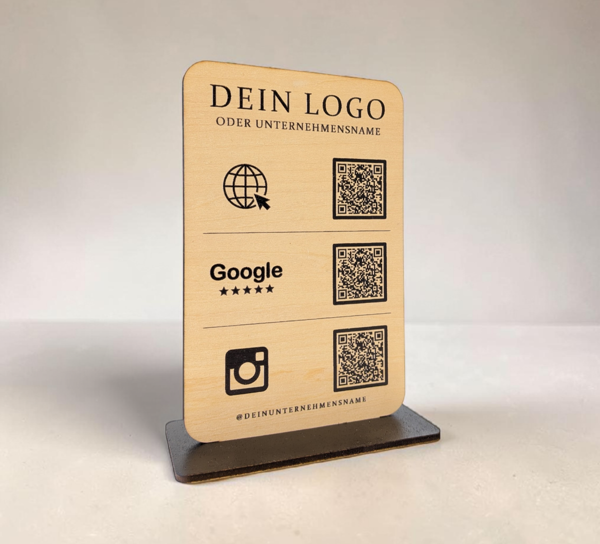Personalisierter QR-Code Aufsteller aus hellem Holz mit schwarzem Standfuß, Logo-Gravur und drei QR-Codes für Website, Google-Bewertungen und Instagram.