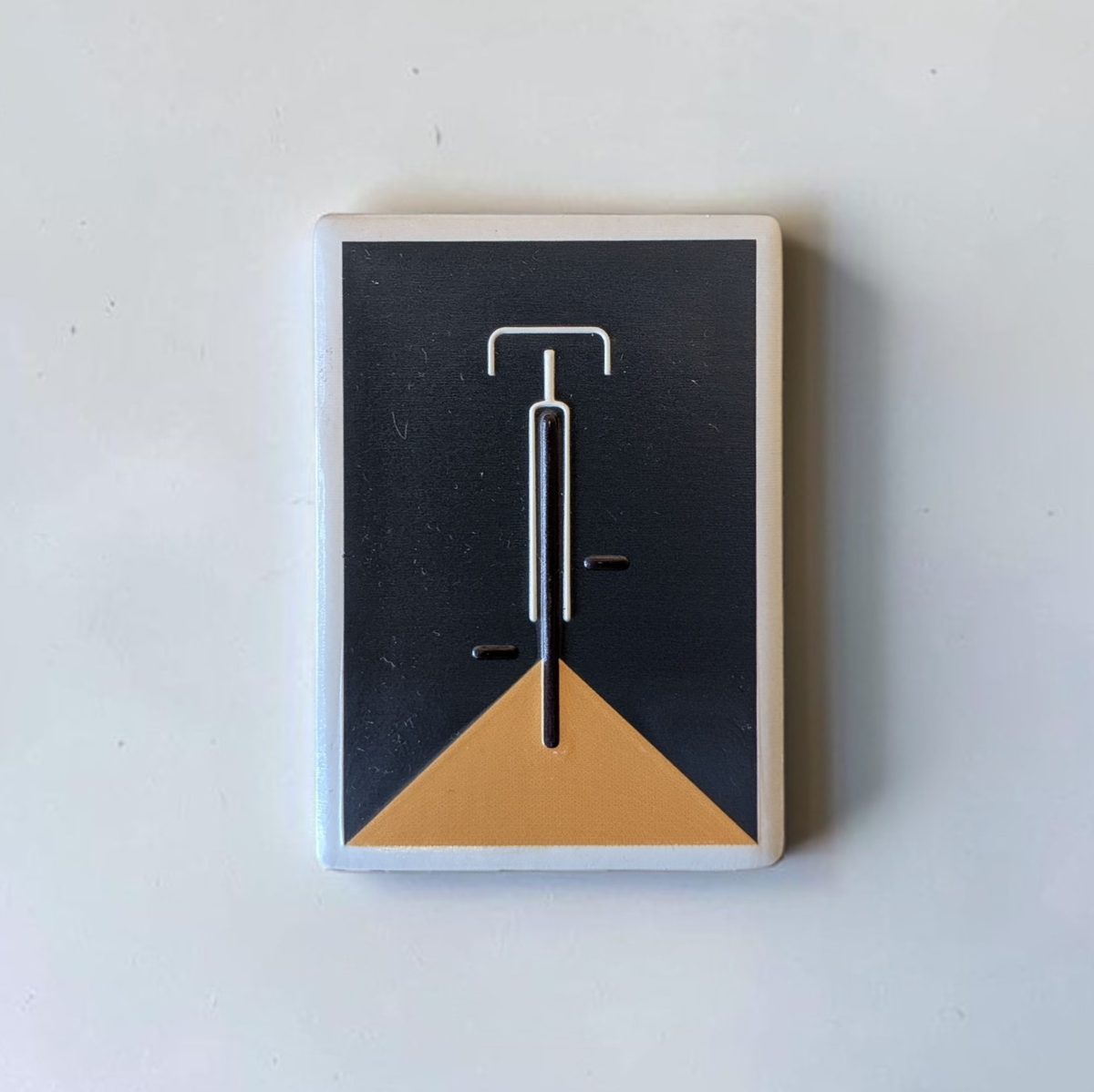 Rechteckiger, weißer Kühlschrankmagnet aus Keramik mit einem minimalistisch dargestellten Fahrrad in kräftigem Blau im Zentrum. Das Design ist schlicht, modern und sauber.