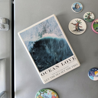 Rechteckiger Keramik-Kühlschrankmagnet (7x5 cm) mit seidenmatter Glasur. Abgebildet ist eine stilisierte Meereswelle in verschiedenen Blautönen mit dem Schriftzug 'OCEAN LOVE' im spürbaren 3D-Relief.