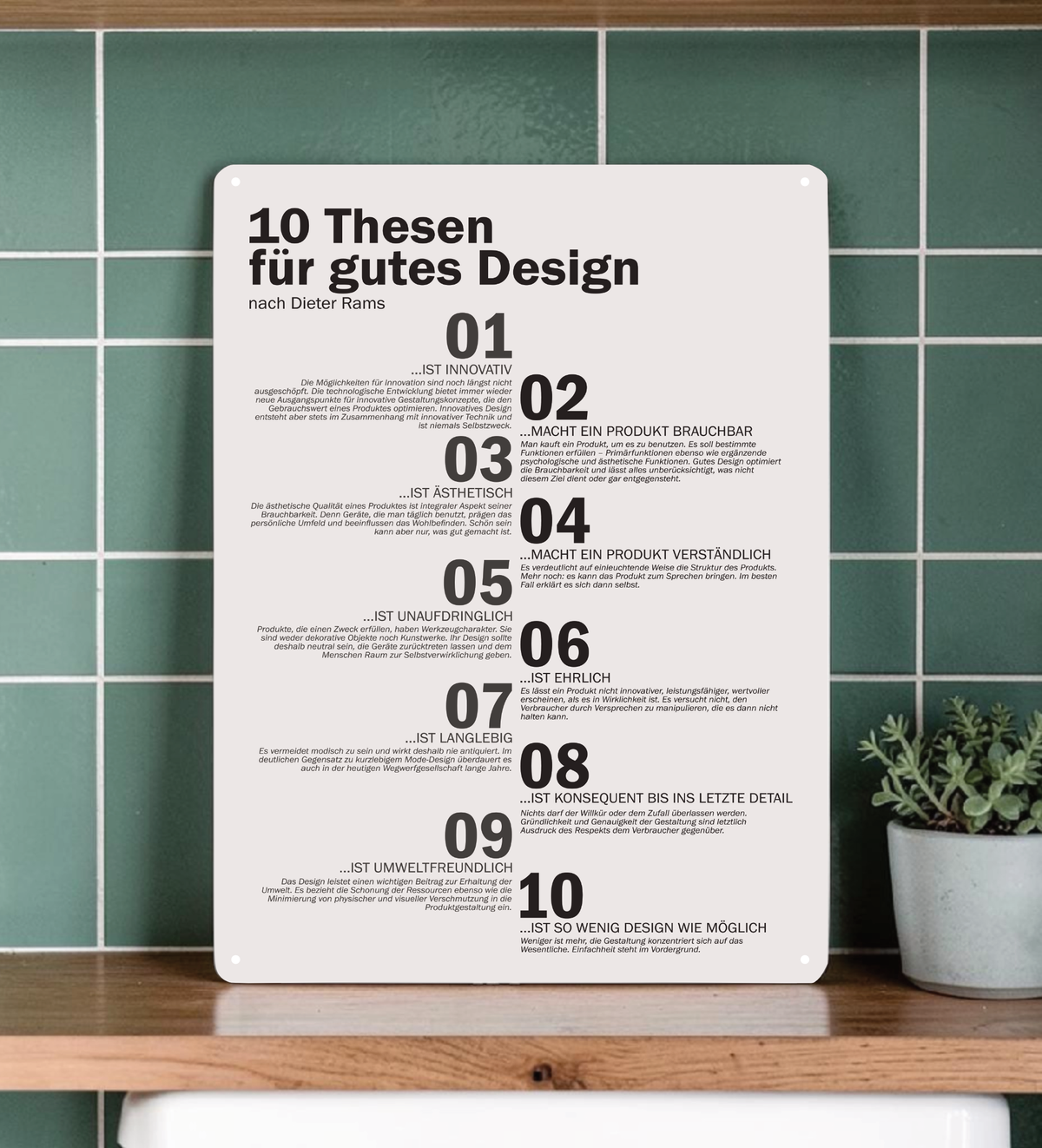 Ein hochkant ausgerichtetes, minimalistisches Metallschild im A3-Format mit den 10 Thesen für gutes Design nach Dieter Rams in deutscher Sprache. Die Typografie ist in klarem, schwarzen serifenlosen Text auf matt-weißem Hintergrund gedruckt. In den vier Ecken befinden sich dezente Vorbohrungen zur Montage.