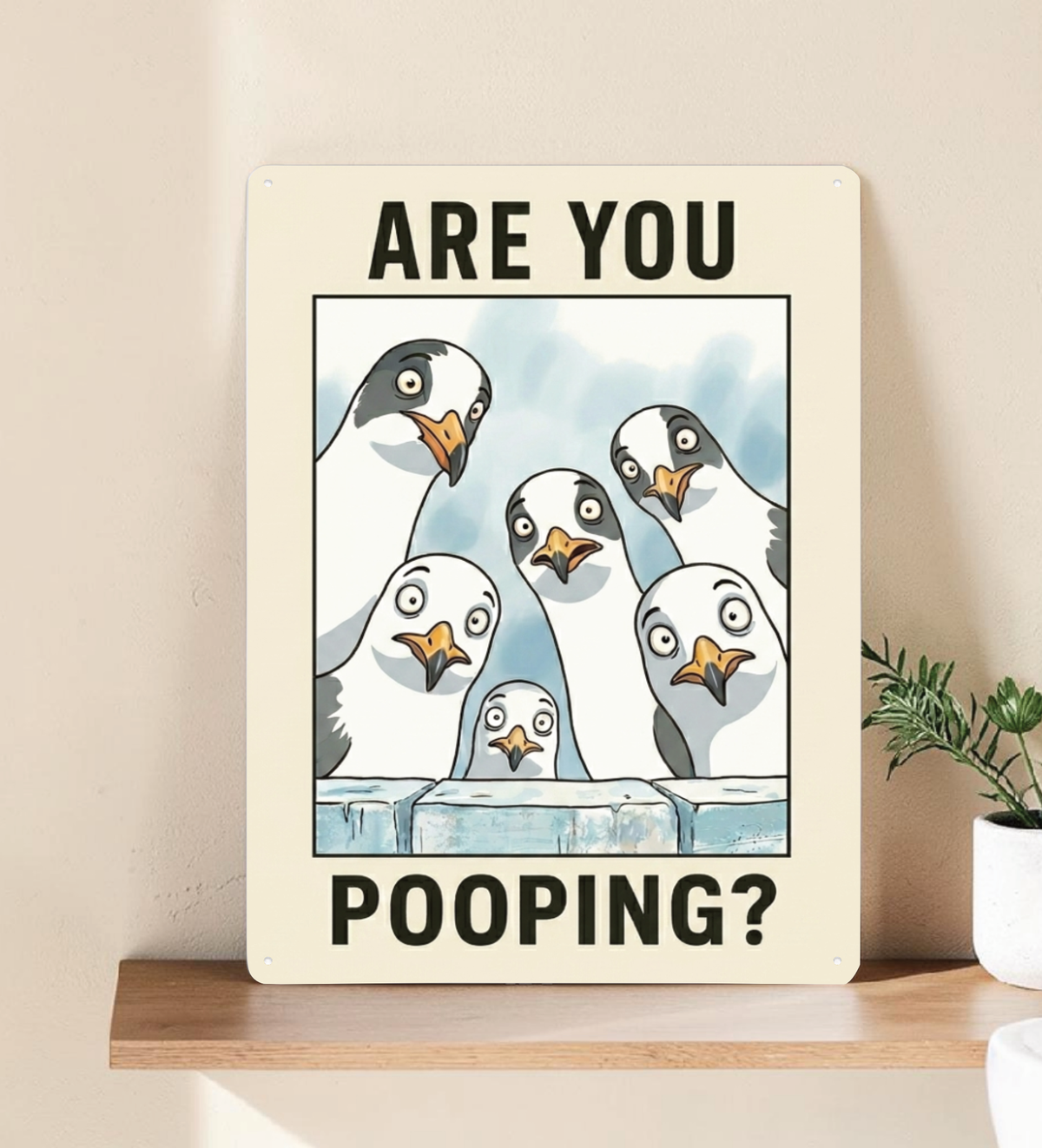 in rechteckiges, weißes Metallschild mit der Aufschrift „ARE YOU POOPING?“ oben und unten. In der Mitte blicken sechs neugierige, comicartig gezeichnete Möwen mit großen Augen über eine blaue Mauer direkt nach vorne. Das Schild steht aufrecht vor einem neutralen, hellen Hintergrund.