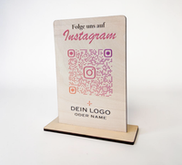 Hochkant stehender, personalisierter Tischaufsteller aus hellem Holz mit flachem Standfuß. Auf der Vorderseite sind ein Wunschtext („Folge uns auf Instagram“), ein QR-Code mit integriertem Instagram-Logo sowie ein Platzhalter für ein individuelles Firmenlogo präzise aufgedruckt.