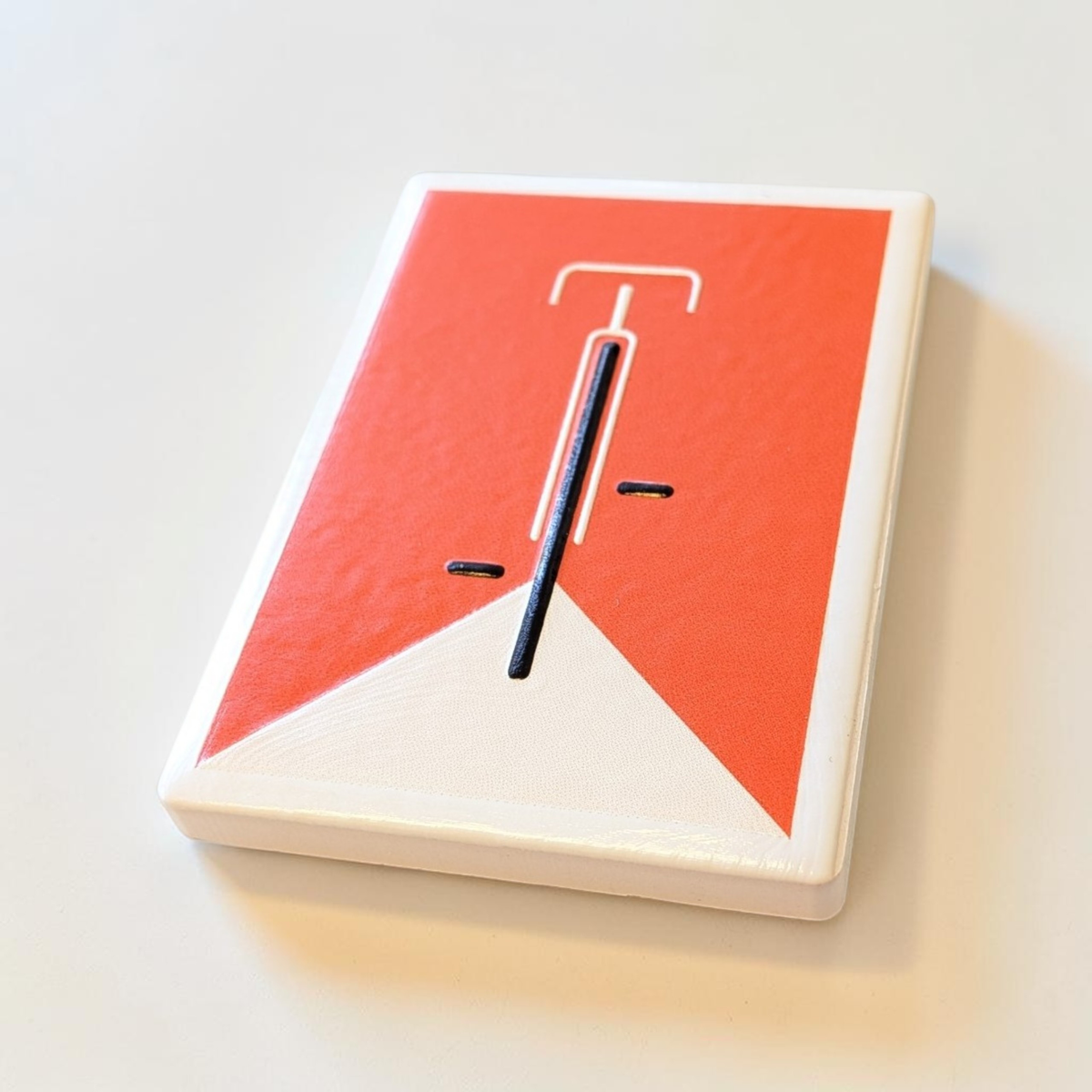 Rechteckiger, weißer Kühlschrankmagnet aus Keramik mit einem minimalistisch dargestellten Fahrrad in kräftigem Orange im Zentrum. Das Design ist schlicht, modern und sauber.