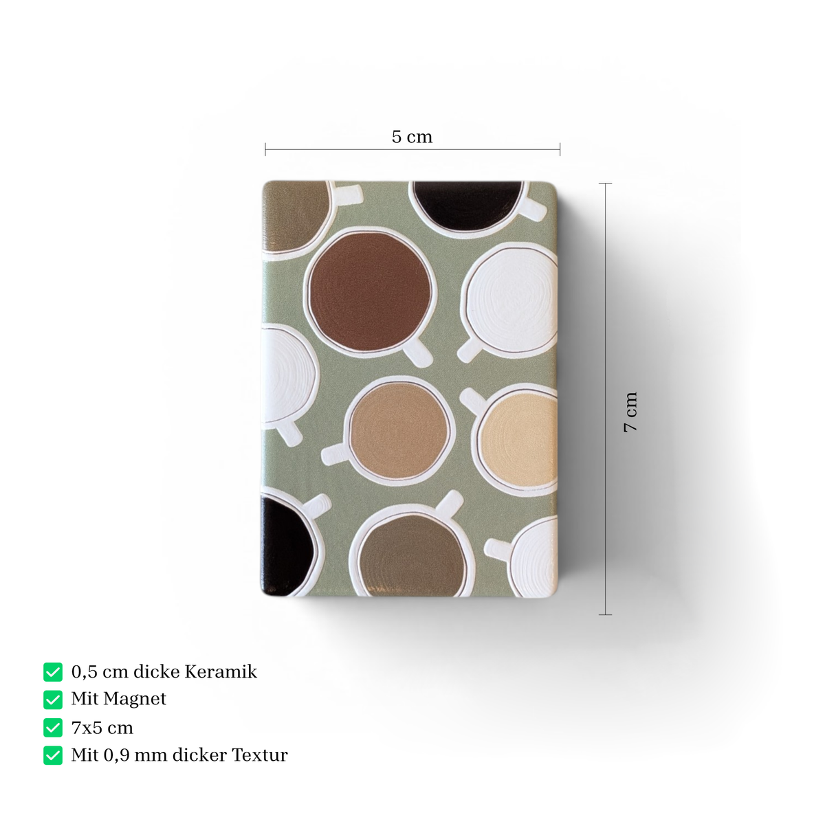 Rechteckiger Keramikmagnet mit abstrakten Kaffeetassen aus der Vogelperspektive in Weiß, Braun und Schwarz auf salbeigrünem Hintergrund. Fühlbare Relief-Struktur und seidenmatte Oberfläche.