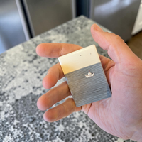 Rechteckiger Keramik-Kühlschrankmagnet im maritimen Stil. Das Design zeigt ein Origamiboot auf dem Wasser mit beigem Hintergrund, mit einer deutlich sichtbaren 3D-Relief-Textur.