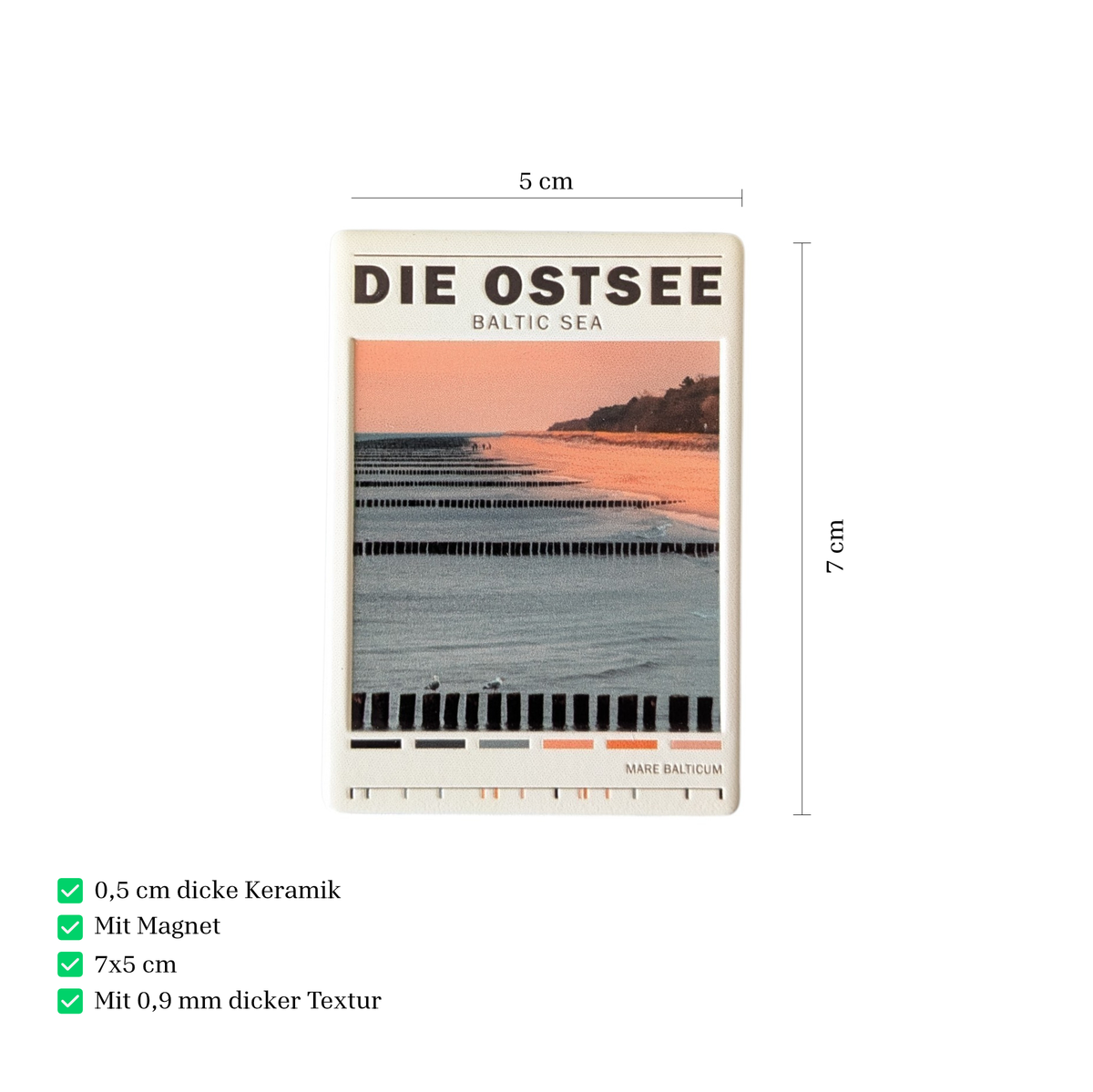 Rechteckiger Keramik-Kühlschrankmagnet (7x5 cm) mit einem Ostsee-Strandmotiv bei weichem Licht, hölzernen Buhnen im Wasser, dem Schriftzug 'DIE OSTSEE BALTIC SEA' und einer kleinen Farbpalette am unteren Rand mit spürbarem 3D-Relief.