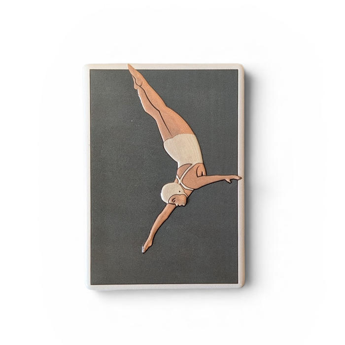Rechteckiger weißer Keramikmagnet mit einer minimalistischen Illustration einer Turmspringerin im Sprung. Das Motiv hat ein fühlbares Relief und eine edle, seidenmatte Oberfläche.