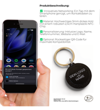 Hand hält einen runden, schwarzen NFC-Schlüsselanhänger aus Holz mit der
Aufschrift "DEIN LOGO -oder- NAME". Im Hintergrund eine kleine grüne Pflanze
auf hellem Tisch.