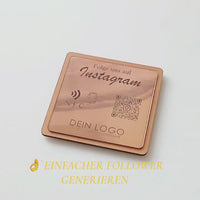 Quadratische, personalisierte Instagram-Follower-Platte aus graviertem Kunststoff in gebürsteter Roségold-Optik auf Holzträger. Hochpräzise Kontrast-Gravur von NFC-Icon und QR-Code.