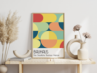 Dieses Bauhaus Poster zeigt dir verschiedene geometrische Formen die bunt dargestellt sind. Das in schönem Blau- und Rottönen gehaltene Poster hat die Bildunterschrift Das Staatliche Bauhaus